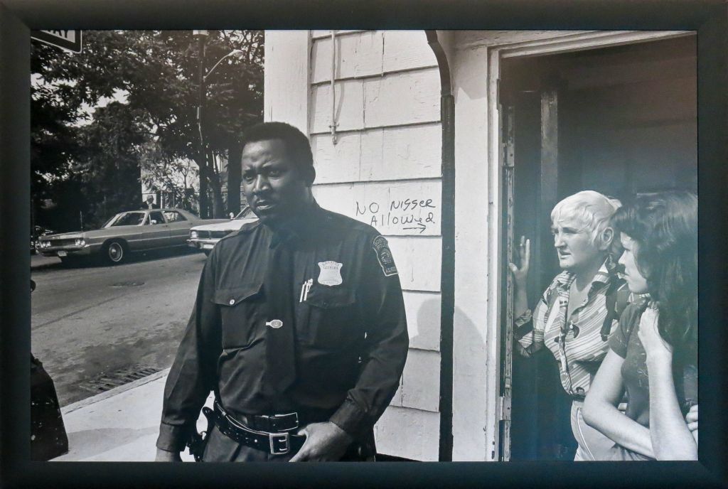 Policier noir devant un club privé avec graffiti : "Interdit aux Nègres" (Boston en 1975)